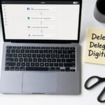 A clean desk flat-lay showing a laptop with a Zapier automation workflow on screen, a sticky note reading 'Delete. Delegate. Digitize.', a pair of scissors, a notebook, and a cup of coffee